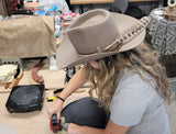 Student making another beautiful hat working the brim with shop tools and skills learned during a day Hat Making Workshop